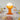 Orange gelato table lamp on a dining table with various dishes and glasses.