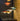 Colorful pendant and table lamps on a dark surface with a stone wall background