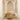 Wooden chair on a textured rug in a room with high arched ceilings and white walls.