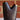 Dark brass vase with gold accents on a white surface with a brick wall background