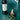 Red wine bottle with a corkscrew on a green surface