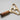Gold and wooden tool on a light gray background