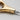 Close-up of a gold tool with a brand name on a light gray background