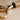 Gold corkscrew with wooden handle on a beige background