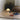 Small portable white lamp on a tatami mat with books and a pillow in a room.