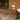 Outdoor setting with table lamps on a wooden deck against a brick wall.