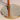 Close-up of a lamp with a gold base and copper-colored cord on a light background