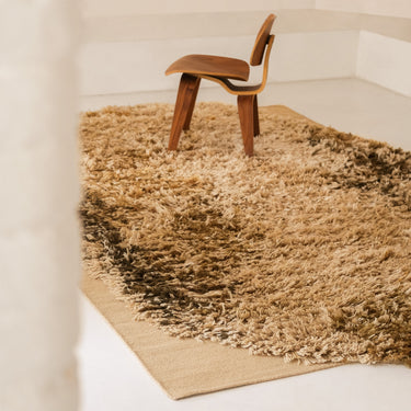 Brown ochre rug with a wooden chair on a white floor