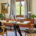 midcentury Tratten conical pendant over a dining table 