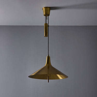 Brass farmhouse style pendant lamp on a grey background