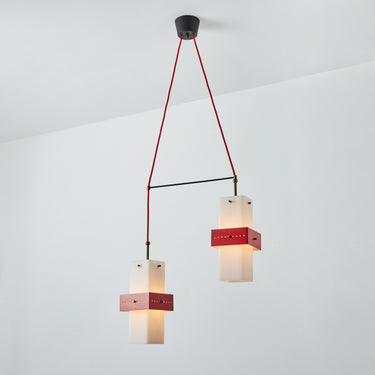 Modern pendant light with red accents on a white background