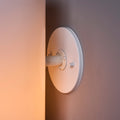 Round light fixture on a wall with a warm glow