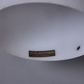 Close-up of a white lampshade with marking with a label on a gray background