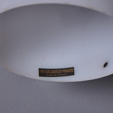 Close-up of a white lampshade with marking with a label on a gray background
