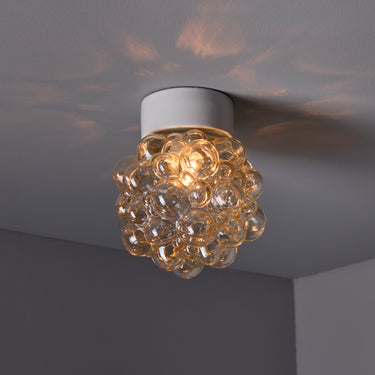 helena tynell vintage bubble glass ceiling light with white canopy on a grey background lit up