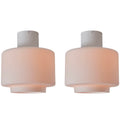 Two flush mount ceiling lights with a white base and pinkish shade on a white background