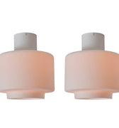 Two flush mount ceiling lights with a white base and pinkish shade on a white background