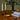 Decorative setup with candles, books, and a vase on a wooden table.