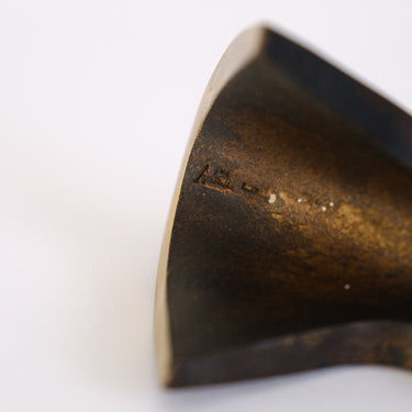 Close-up of a  brass bookend on a white background