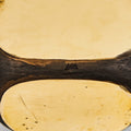 Close-up of a brass bookend stamped "Aubock made in austria" black rim on a light gray background