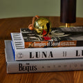 brass jingle bell paperweight on stack of books