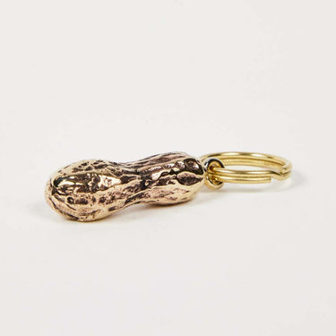 Gold peanut-shaped keychain on a light gray background
