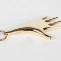 polished brass auböck hand keyring on a white background