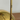 Close-up of a brass lamp stem on a wooden surface with a white background