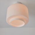 Ceiling light fixture with a white glass shade on a plain background