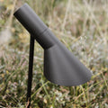 AJ Garden Modern outdoor pathway light with a black finish on a blurred natural background