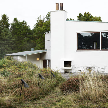 Modern white house with a garden and outdoor pathway lighting 