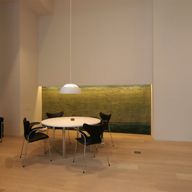 Modern dining room with a round table and chairs in a minimalistic setting AJ royal white pendant and fritz hansen chairs