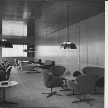 Royal SAS hotel interior design with chairs, tables, and hanging lights in a room.