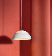 White AJ Royal pendant light against a red textured wall