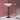 A modern table lamp with a white layered shade and a dark bronze base, set on a white surface against a dusty pink wall with a mirrored box behind it.