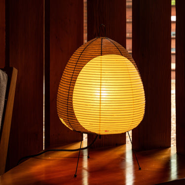 Akari lamp with a warm glow on a wooden floor