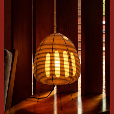 Akari 1AG table lamp with a warm glow on a wooden floor