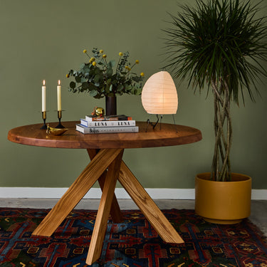 Wooden table with decorative items against a green wall