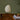 Unlit akari 1N White paper lamp on a wooden table with candles and books against a green wall