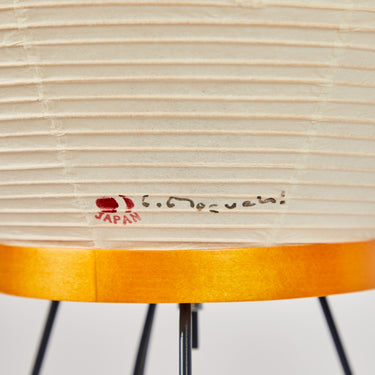 Lamp with wooden base and ribbed beige shade on a white background