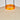 Close-up of a woven lampshade with an orange ring and black wires on a light gray background