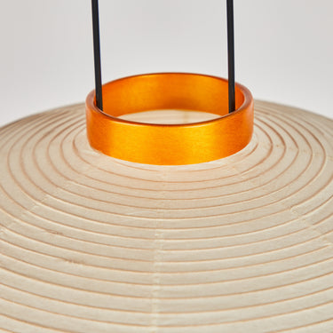 Close-up of a woven lampshade with an orange ring and black wires on a light gray background