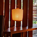 akari rounded washi paper table lamp on warm dark wood table