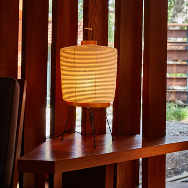 akari rounded washi paper table lamp on warm dark wood table
