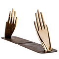 decorative hand brass aubock hands with a wooden base on a white background