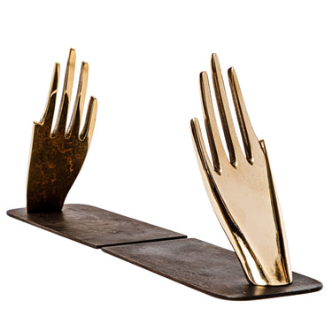 decorative hand brass aubock hands with a wooden base on a white background