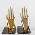 brass hand-shaped bookends on a white background