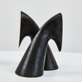 Black brass bookend sculpture on a white background