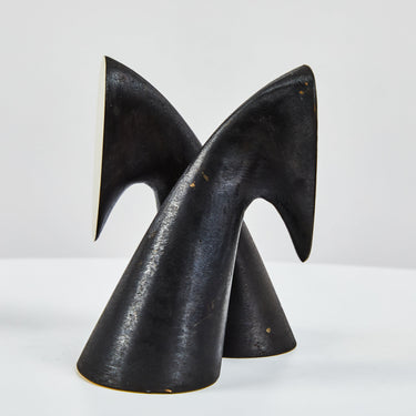 Black brass bookend sculpture on a white background