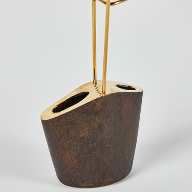 Decorative vase with a gold stand on a light gray background